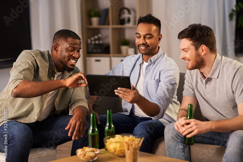 friendship  leisure and people concept - male friends with tablet pc computer drinking beer at home at night