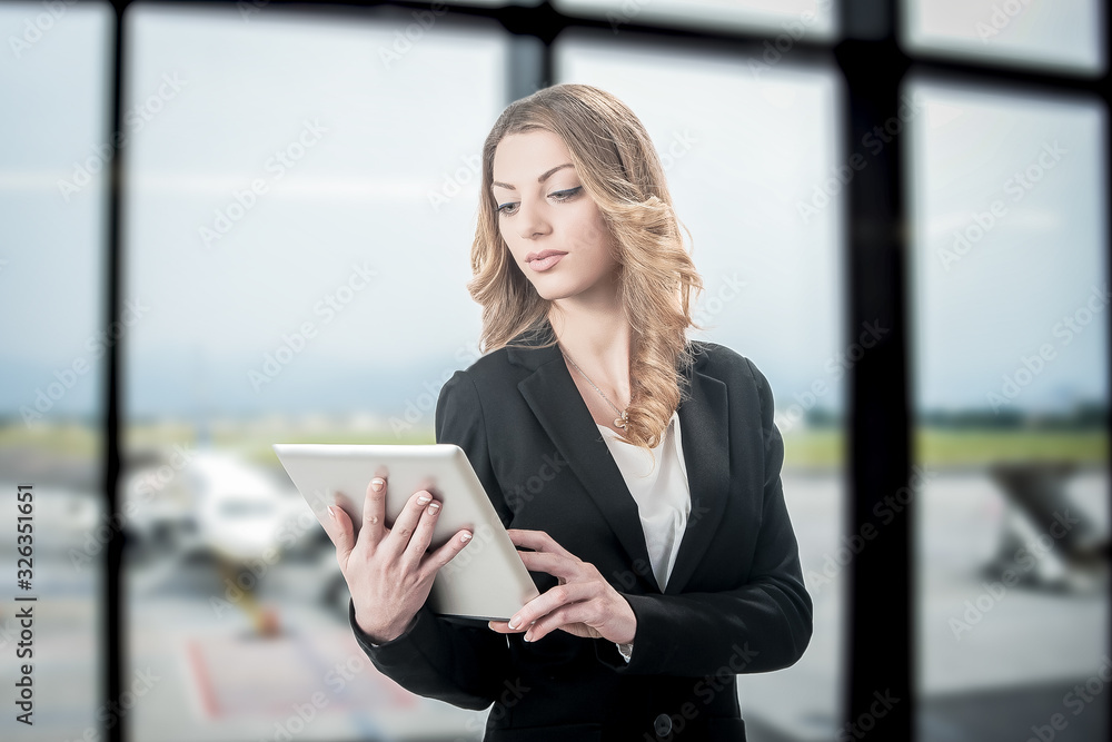 Beautiful business woman working on laptop while waiting for her flight in an airport Beautiful business woman working on laptop while waiting for her flight in an airport