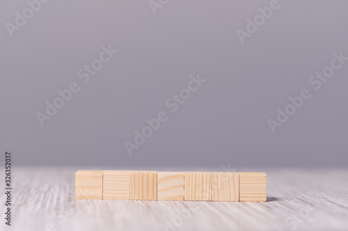 Fototapeta Naklejka Na Ścianę i Meble -  wooden square figures in line on a gray background