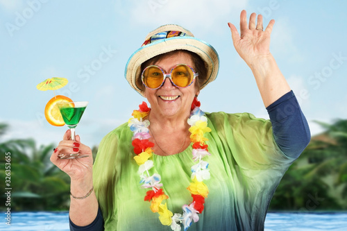 Old lady on vacation with a cocktail glass in hand