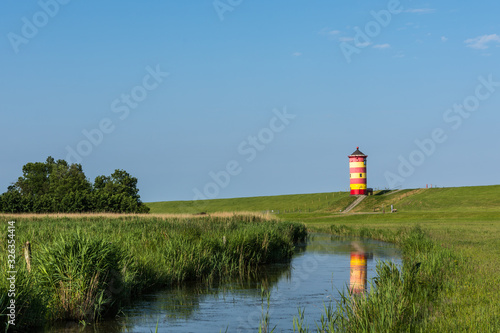 Pilsumer Leuchtturm mit Spiegelung im Wasser, Pilsum, Nordseeküste, Ostfriesland, Niedersachsen, Deutschland 