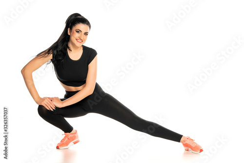 young and happy sporty woman doing stretching exercises
