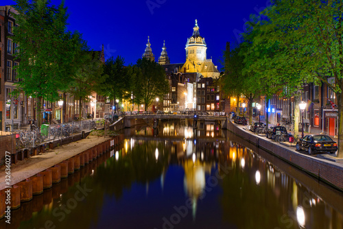 Night view of buildings and boats along the canal in Amsterdam, Netherlands