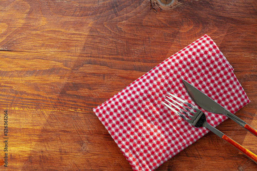 Obraz premium Red checkered napkin or tablecloth on wooden table, copy space