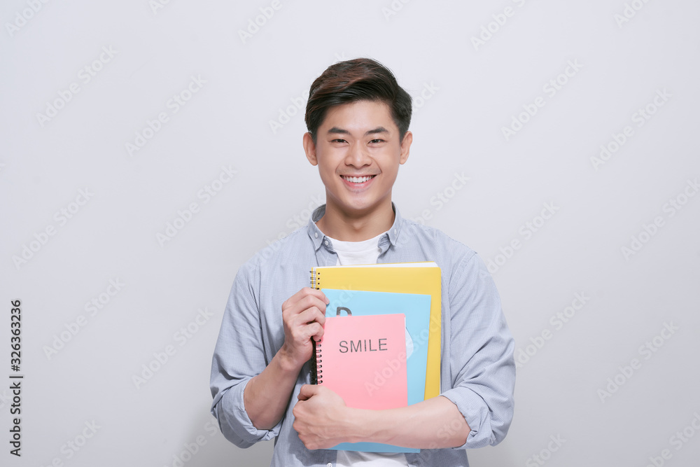 Young smiling student man holding books Young smiling student man holding books