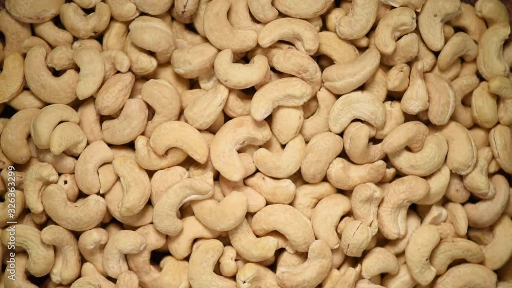 Cashew nuts on rotating background. Food ingredient background. Vegan, vegetarian diet. Healthy lifestyle. Natural dry fruits and nuts concept Cashew nuts on rotating background. Food ingredient background. Vegan, vegetarian diet. Healthy lifestyle. Natural dry fruits and nuts concept