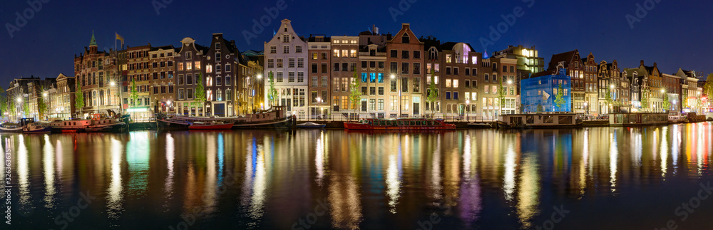 Panorama of the buildings along the canal at night in Amsterdam, Netherlands