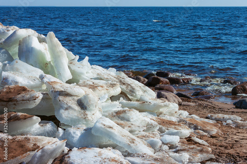 big piecies of ice on the sandy beach of Baltic sea photo