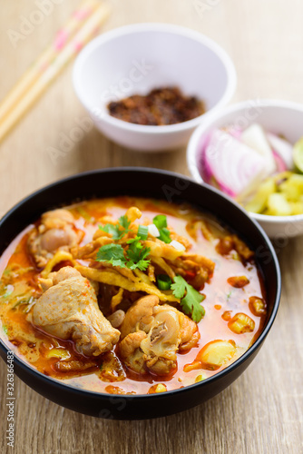 Traditional Northern Thai food (Khao Soi), spicy curry noodles soup with coconut milk and chicken in a bowl