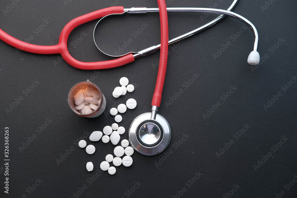 top view of stethoscope and pills on black background top view of stethoscope and pills on black background
