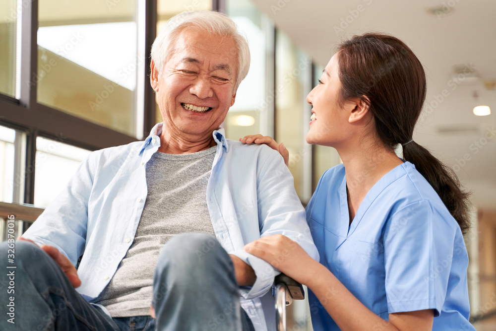 young friendly asian female caregiver talking to elderly man in nursing home young friendly asian female caregiver talking to elderly man in nursing home