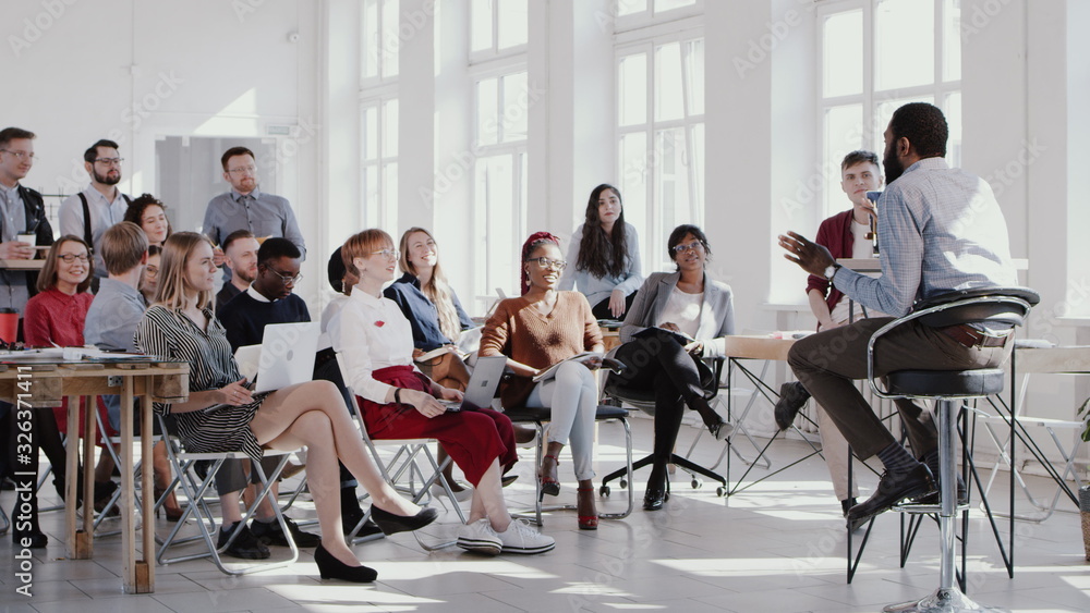 RED EPIC Young happy black CEO businessman giving a speech for multiethnic managers team at trendy office slow motion. RED EPIC Young happy black CEO businessman giving a speech for multiethnic managers team at trendy office slow motion.