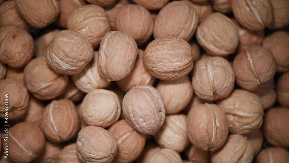 Walnut nuts on rotating background. Food ingredient background. Vegan, vegetarian diet. Healthy lifestyle. Natural dry nut concept Walnut nuts on rotating background. Food ingredient background. Vegan, vegetarian diet. Healthy lifestyle. Natural dry nut concept
