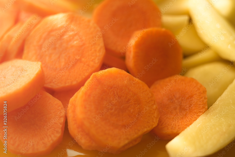 Raw round slices of carrots and potatoes close-up. Raw round slices of carrots and potatoes close-up.