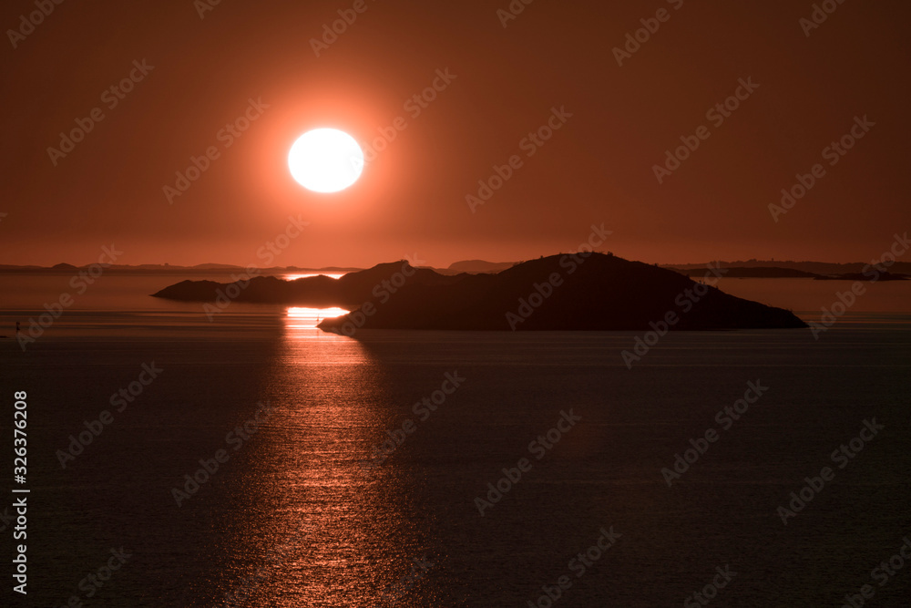 glowing sunset and small silhouette islands glowing sunset and small silhouette islands