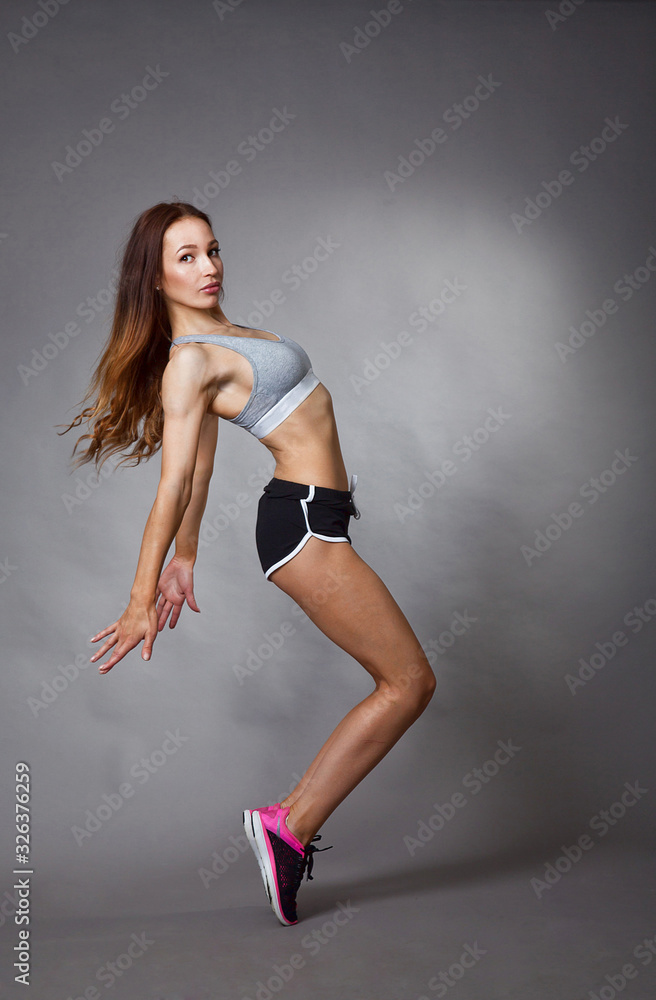 Obraz premium Young sexy athletic girl shows off her body in the Studio after a workout