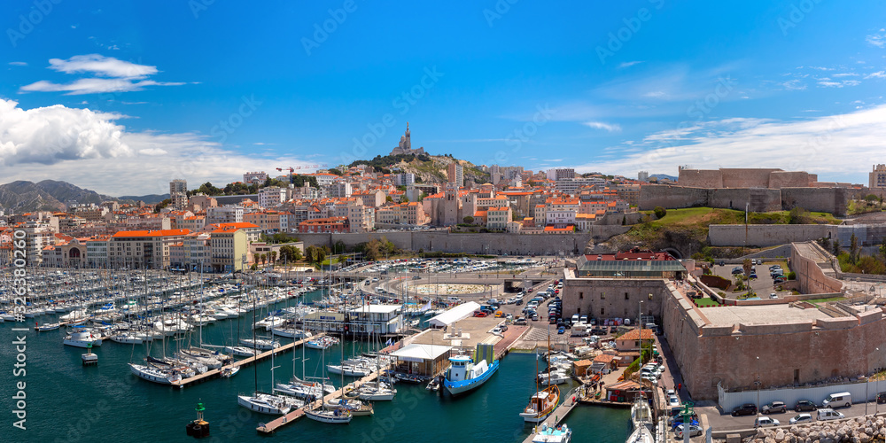 The old Vieux Port and Basilica Notre Dame de la Garde in the historical city center of Marseilles on sunny day, France