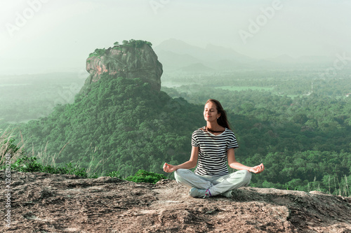The concept of a healthy lifestyle of the body and soul. Beautiful woman relaxing and meditating outdoor mountains