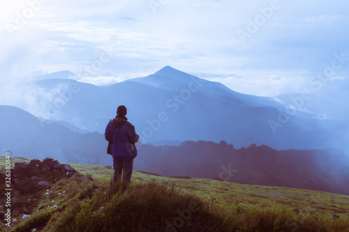 Man silhouette on cloudy mountains. Travel concept. Landscape photography