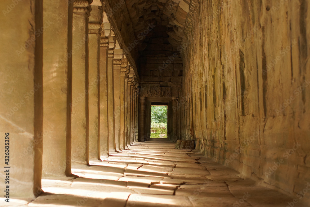 Columns at sunny South Gallery, Angkor Wat Temple, Cambodia. Sunbeams going through columns and shadows on floor Columns at sunny South Gallery, Angkor Wat Temple, Cambodia. Sunbeams going through columns and shadows on floor