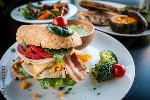 Close up image of Loaded Sandwich breakfast with a lot of vegetables and broccoli soup.