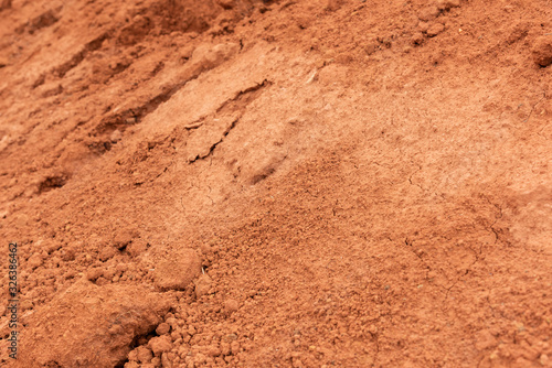 Dry cracked slope red dirt closeup