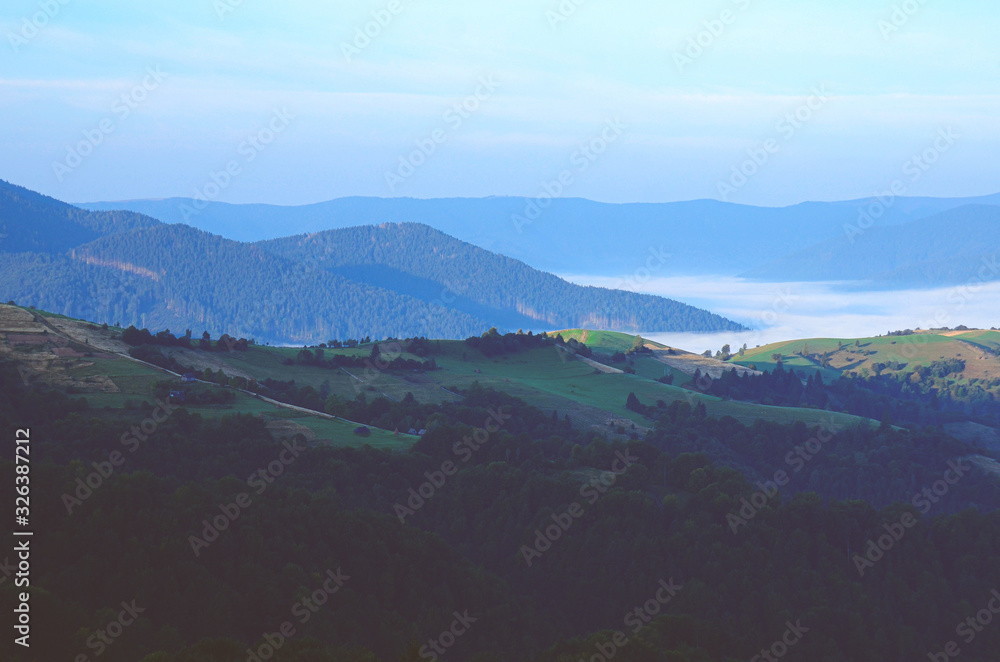 Mountain ranges covered with fog against the dawn sky