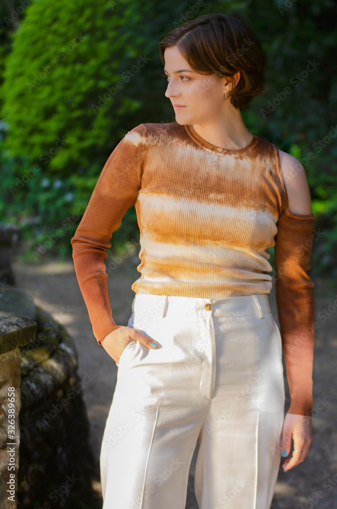 Fototapeta premium portrait of young woman with a tie-die shirt in a park