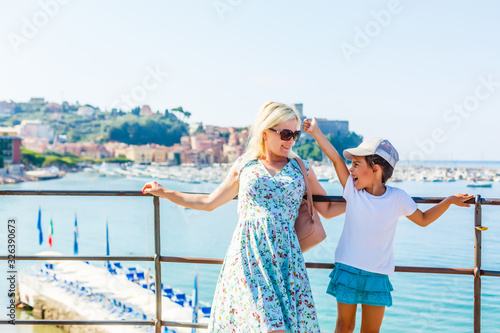 mother and daughter at Lake Garda with mountains, lake and town on the background. Lake Garda is the largest lake in Italy. Lifestyle, Holidays and Travel Concept. © Angelov