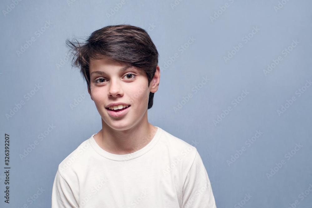 Portrait of a smiling teenager boy on a blue background Portrait of a smiling teenager boy on a blue background