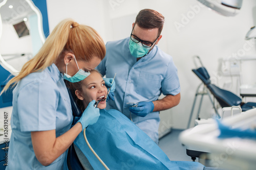 Dentist examining patient s teeth in clinic