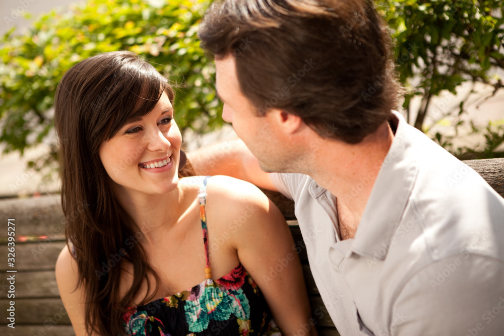 Happy Young Couple Sitting on Bench Downtown Happy Young Couple Sitting on Bench Downtown