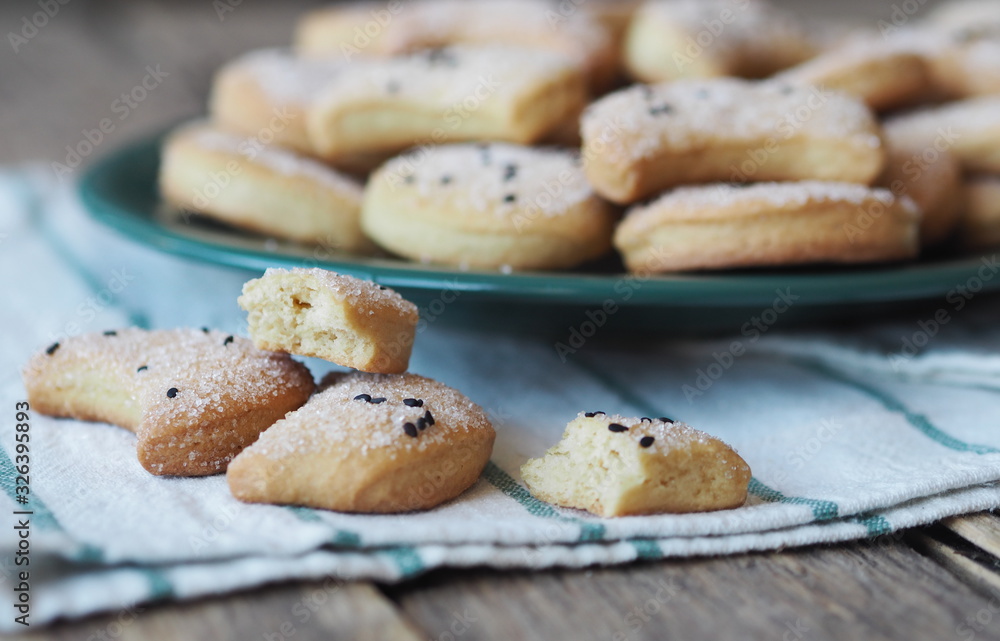 Homemade shortbread cookies sprinkled with sugar with black sesame seeds on a wooden rustic table. Photo for the holiday, Shrovetide, Christmas, New Year, Easter.