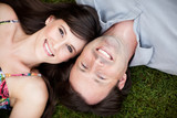 Happy Young Couple Lying in Grass Together Outside