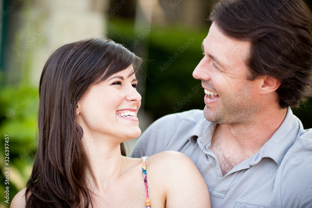 Happy Young Man and Woman Laughing While Sitting on Sidewalk Happy Young Man and Woman Laughing While Sitting on Sidewalk