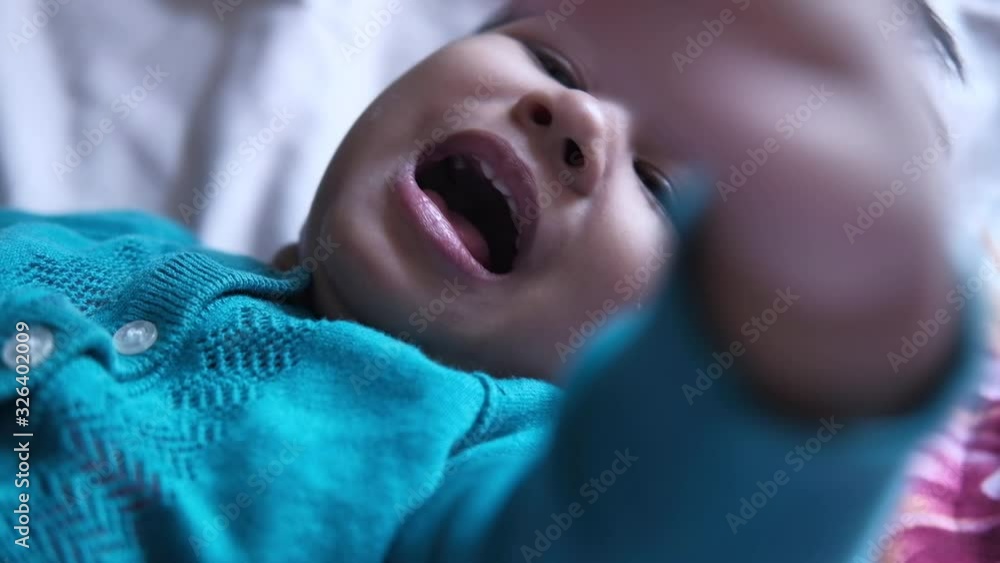 Close up of baby girl on bed crying Close up of baby girl on bed crying