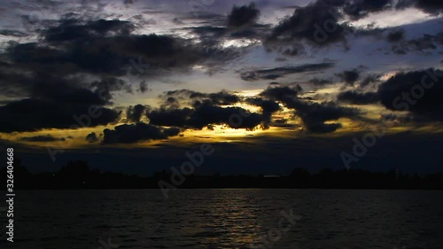 moving dark clouds, flowing water and reflections, from light to dark, orange background photo