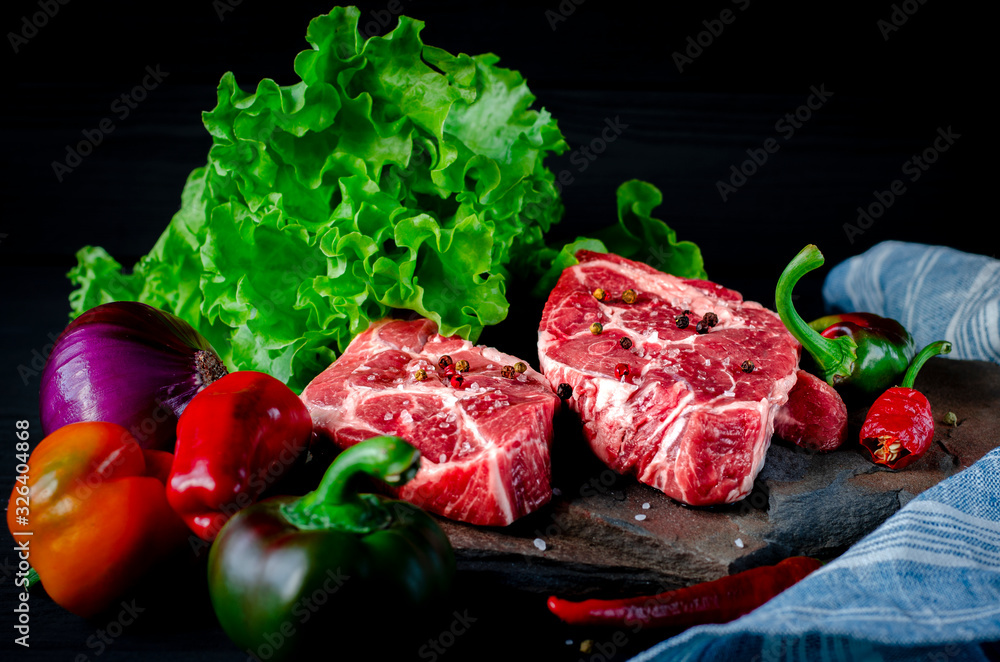 Meat concept. Meat steaks are ready to cook with vegetables lying on the table