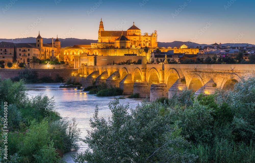 Panoramic night sight in Cordoba, with the Roman Bridge and Mezquita on the Guadalquivir River. Andalusia, Spain.
