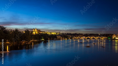 View of the city Prague in Czech Republic with colorful paddle boats day to night timelapse on the Vltava river with beautiful sky
