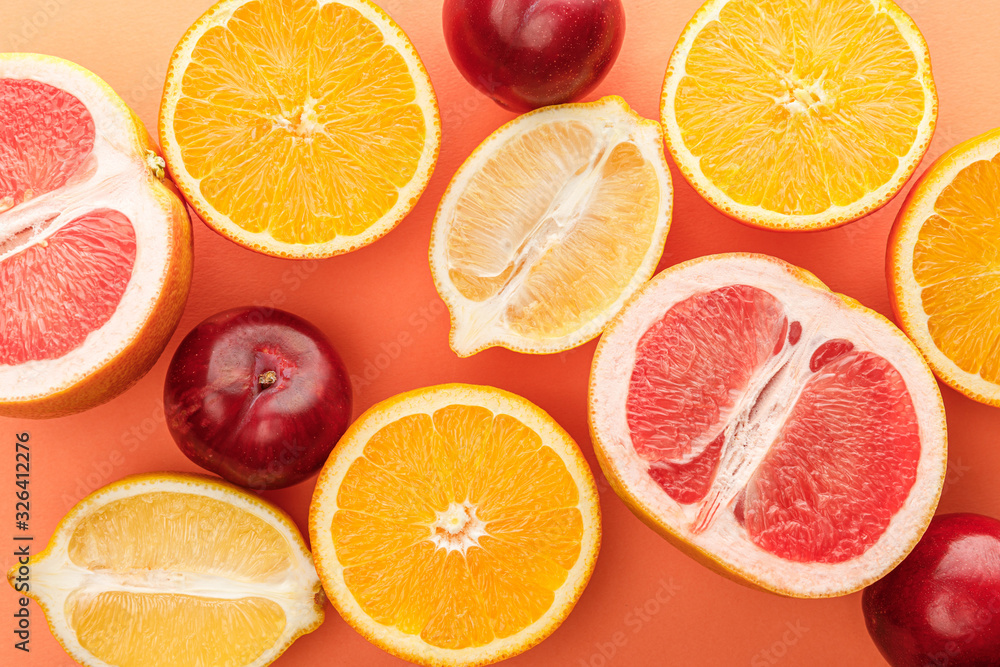 Top view of citrus fruits halves and apples on orange background Top view of citrus fruits halves and apples on orange background