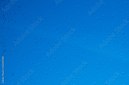 Drops of water on the glass. Rain. Blue background