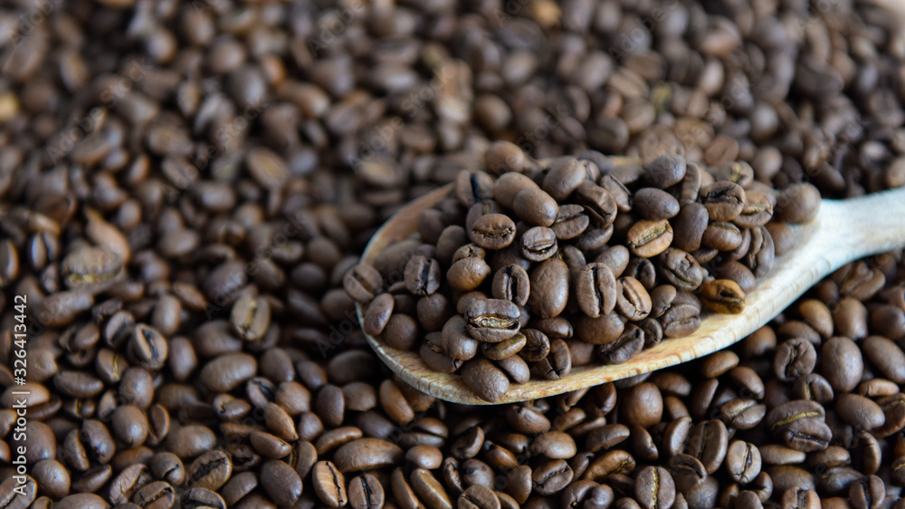 Fototapeta premium roasted coffee beans on a wooden spoon
