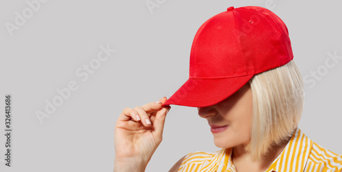 Blank red baseball cap mockup template, wear on women head, isolated, clipping path. Woman in clear hat and t shirt mock up holding visor of caps. Cotton basebal cap mokcup on delivery guy. photo