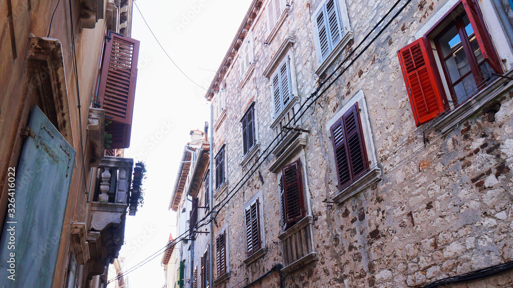 Street with beautiful old buildings of different colours in Rovinj, Croatia