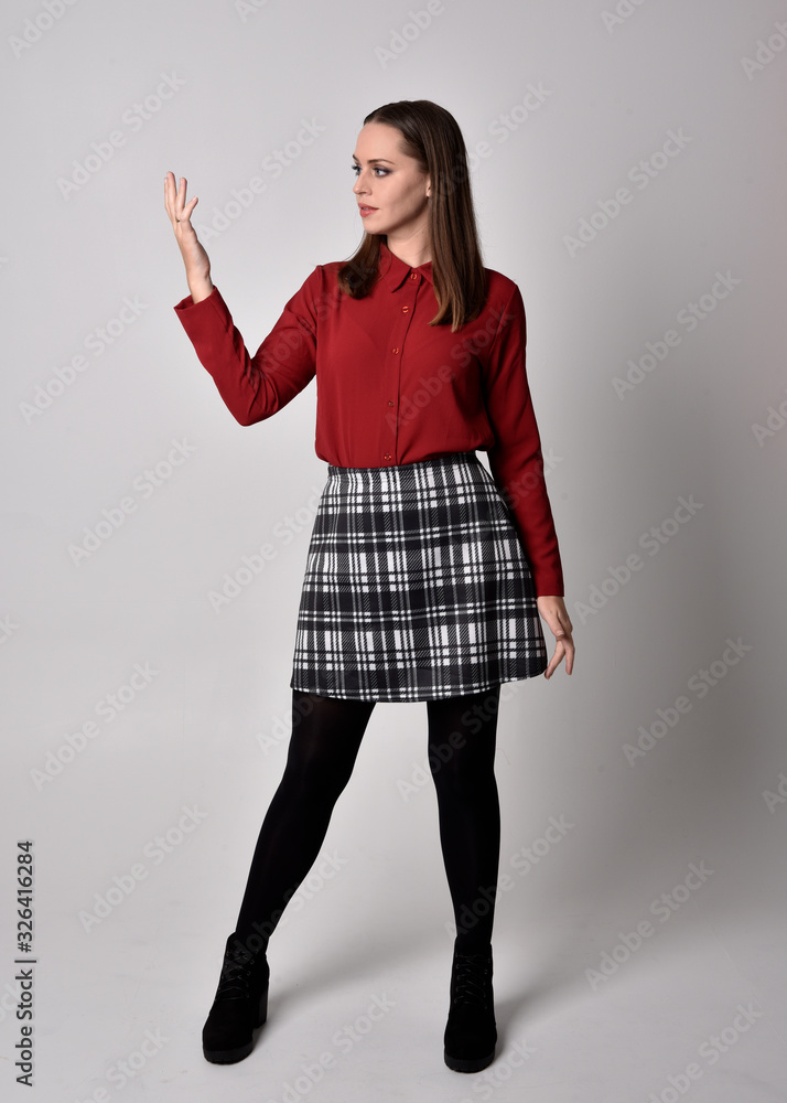 full length portrait of a pretty brunette girl wearing a red shirt