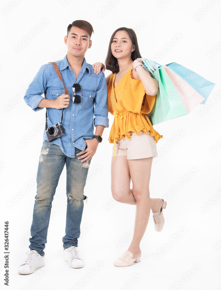 Asian pretty young woman sitting on whitel background. She smiling and  happy shopping bags. she nice-looking lovely attractive shine.Friend  happy to shopping time.