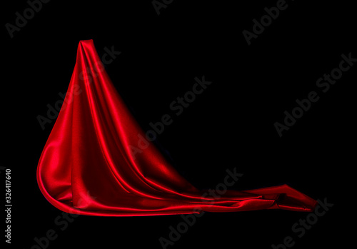 Satin red fabric on a black background. Abstract design.
