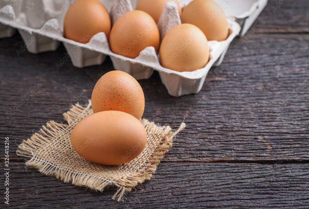 Raw eggs in egg box on rustic wooden background. Raw eggs in egg box on rustic wooden background.