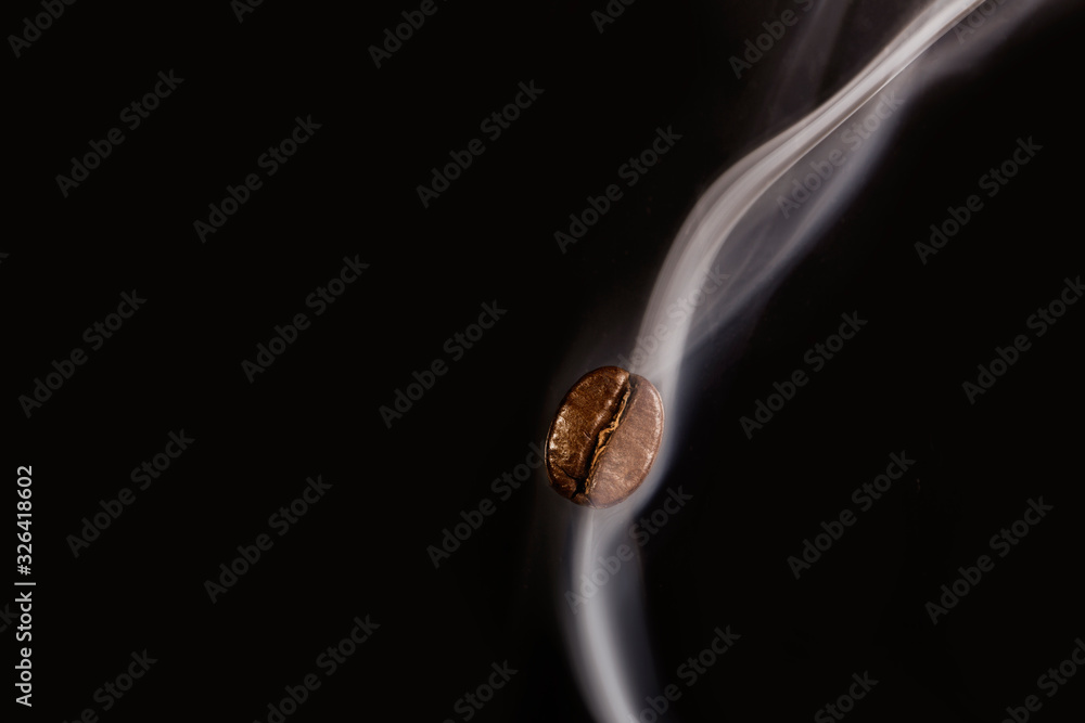 Roasted coffee beans. Seeds of freshly roasted coffee with smoke. Coffee beans closeup with emphasis on the grain with smoke. Roasted coffee beans. Seeds of freshly roasted coffee with smoke. Coffee beans closeup with emphasis on the grain with smoke.